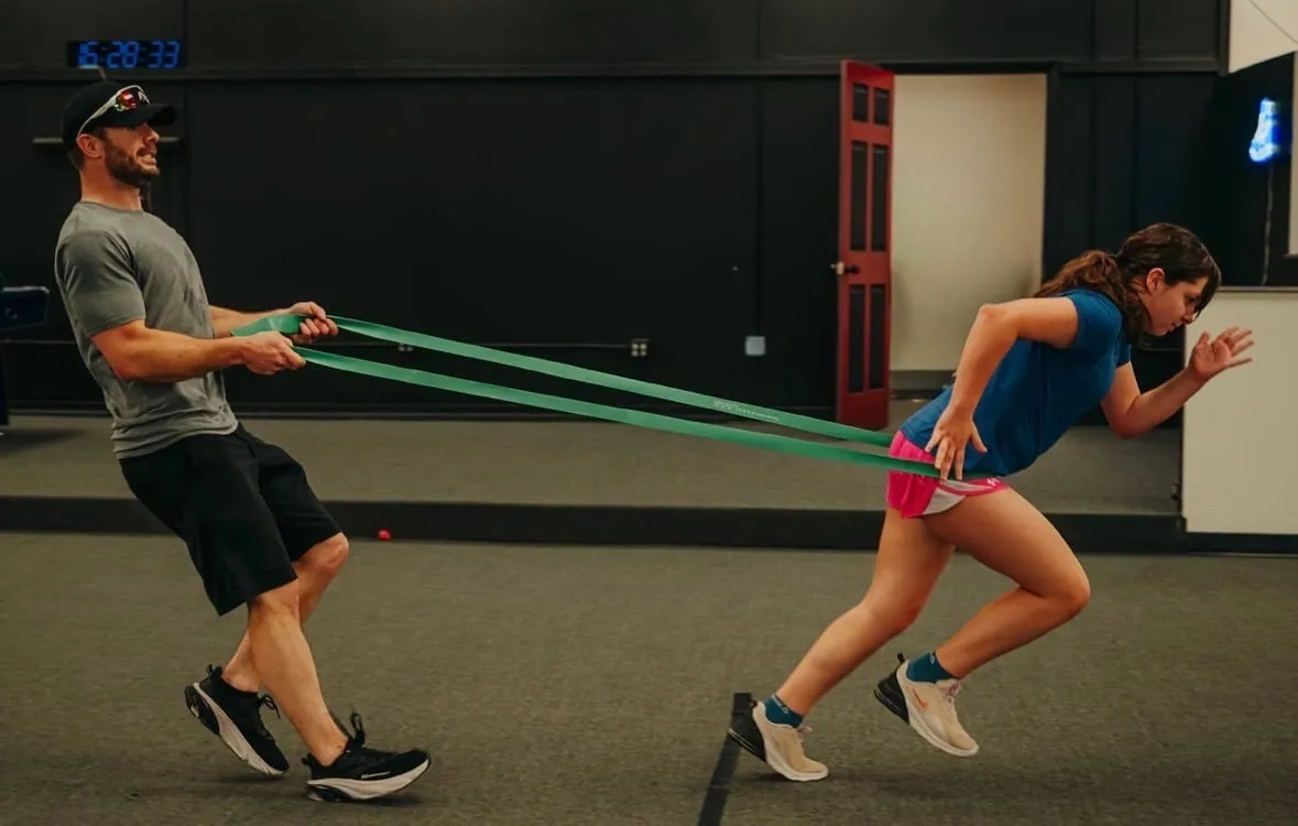 Coach resisting an athlete with a speed band